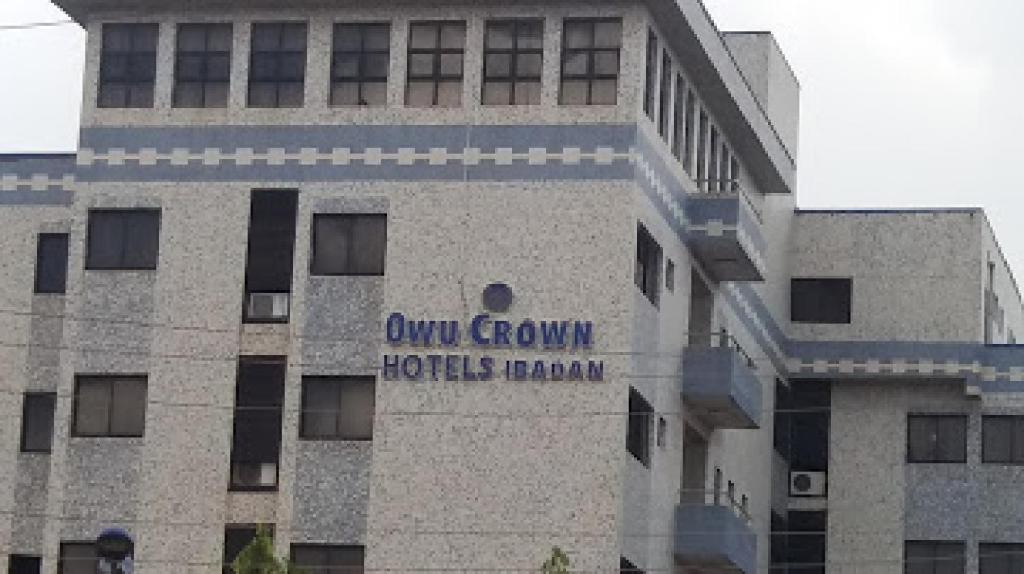 a building with a sign on the side of it at Room in Lodge - Owu Crown Hotel - Deluxetwin Bed Room in Ibadan