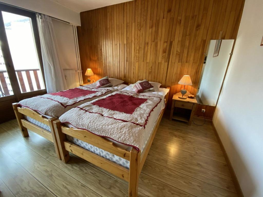 een slaapkamer met een groot bed en een houten muur bij Studio Brides-les-Bains, 1 pièce, 2 personnes - FR-1-512-205 in Brides-les-Bains