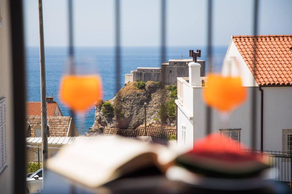 un libro abierto sentado en una mesa frente a una ventana en Royal Fort - Lovrijenac en Dubrovnik