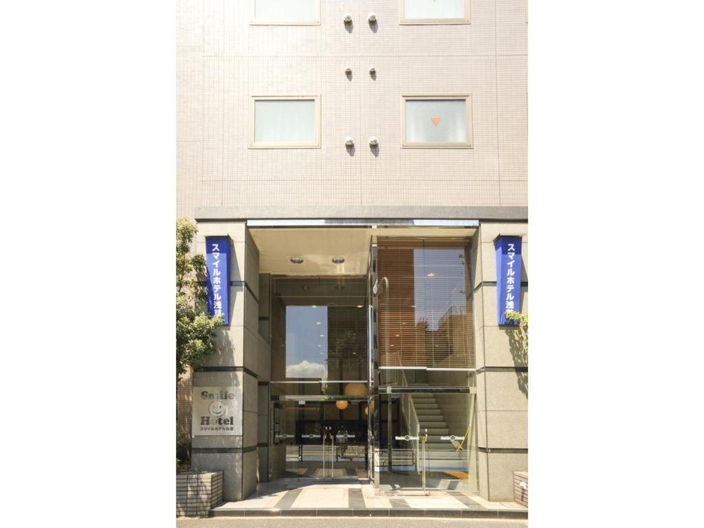 zewnętrzny widok na budynek z drzwiami obrotowymi w obiekcie Smile Hotel Asakusa w Tokio