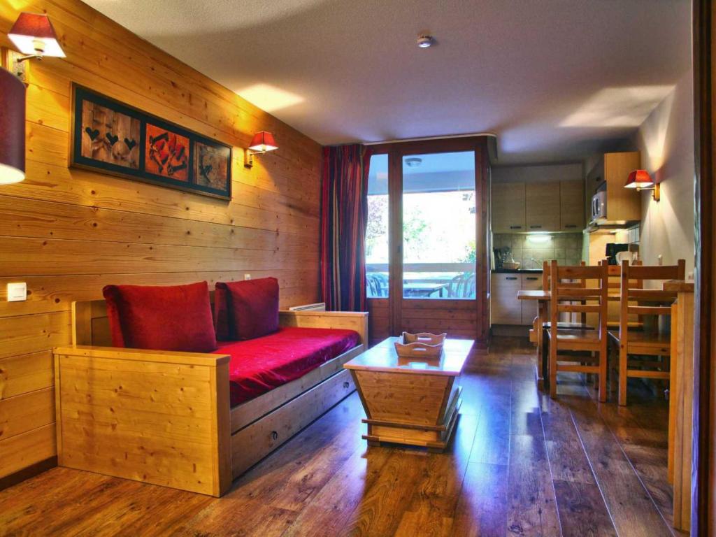 ein Wohnzimmer mit einem roten Sofa und einem Tisch in der Unterkunft Studio Brides-les-Bains, 1 pièce, 4 personnes - FR-1-512-49 in Brides-les-Bains