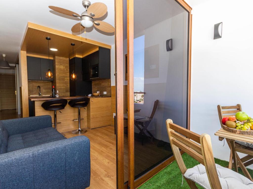 a living room with a blue couch and a kitchen at Lighthouse Friendly Holiday Home in Playa del Ingles