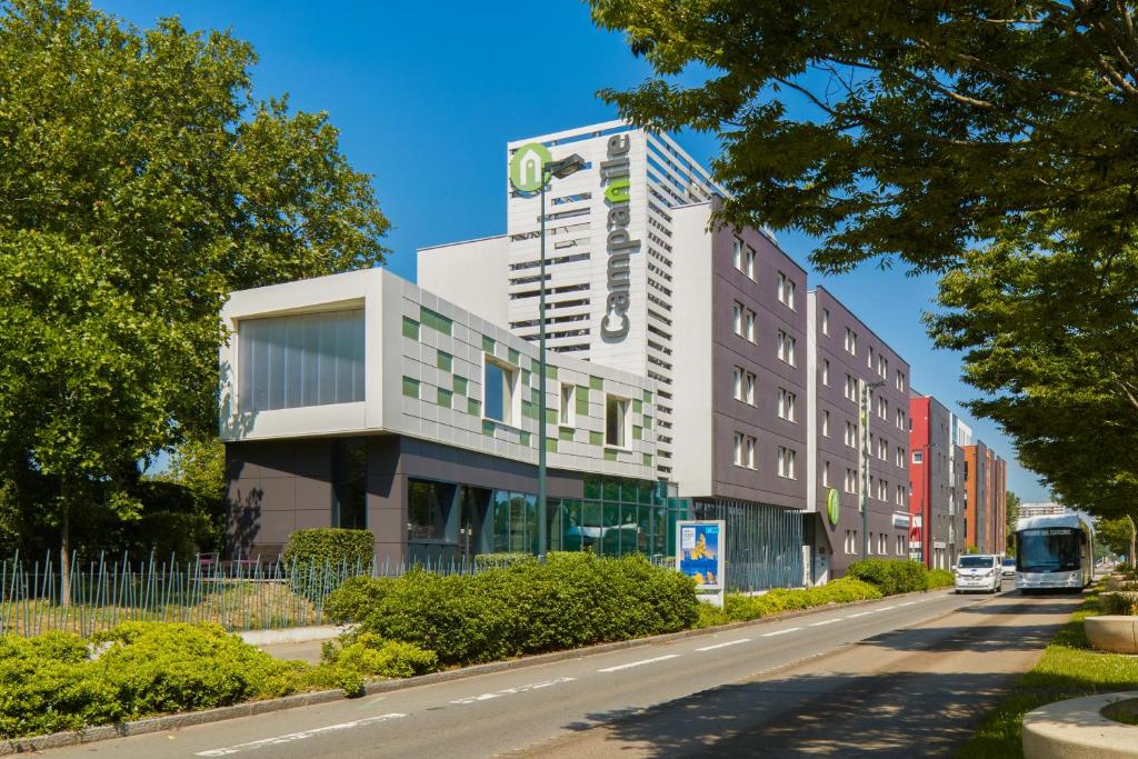 a building on the side of a street with a bus at Campanile Nantes Centre - Saint Jacques in Nantes