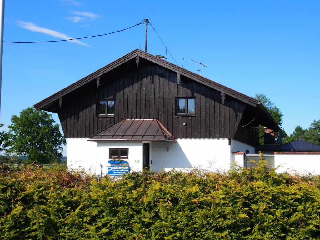 a building with a black roof and white at Ferienhaus Mariengrund in Bernau am Chiemsee