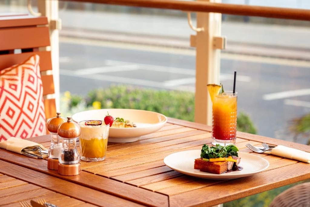 a table with a plate of food and a drink at Roslin Beach Hotel in Southend-on-Sea