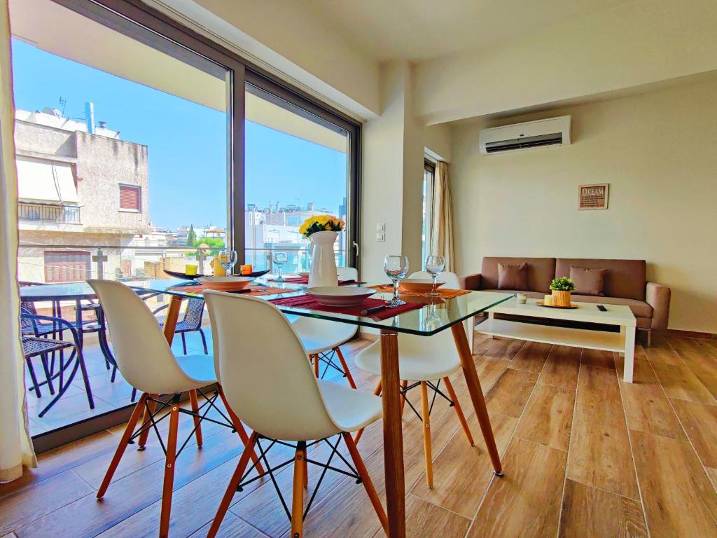 comedor con mesa y sillas y ventana grande en WSD Luxury Bright 2BD Apt with Sea view Balcony, en Atenas