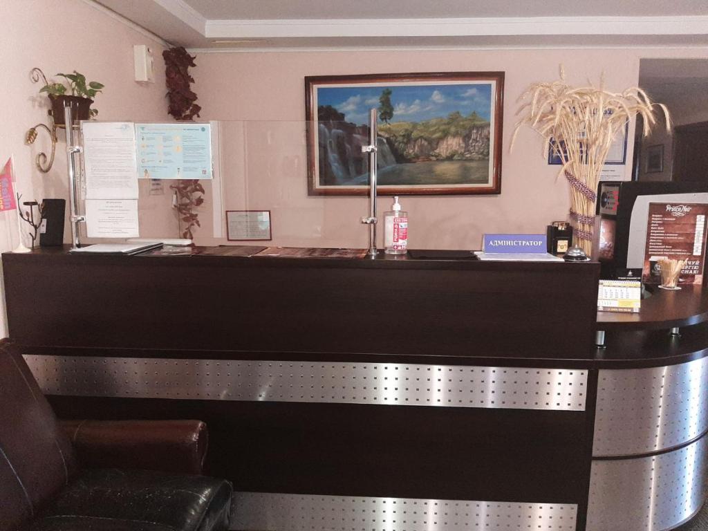 a reception desk in a bar with a picture on the wall at Отель in Malyn