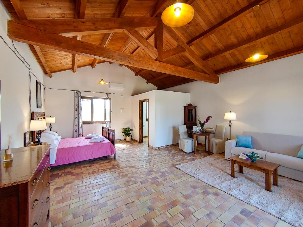 uma grande sala de estar com uma cama e um sofá em Masseria Crocco em Montalbano Ionico
