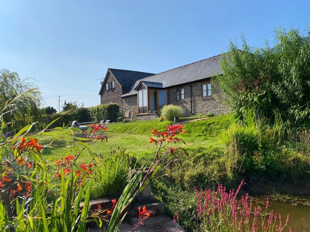 una casa con un jardín delante de ella en The Retreat en Bredwardine