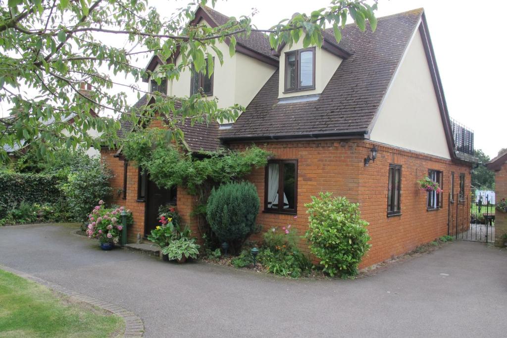 uma casa de tijolos com um telhado preto em Burnt Mill Cottage em Burnham on Crouch