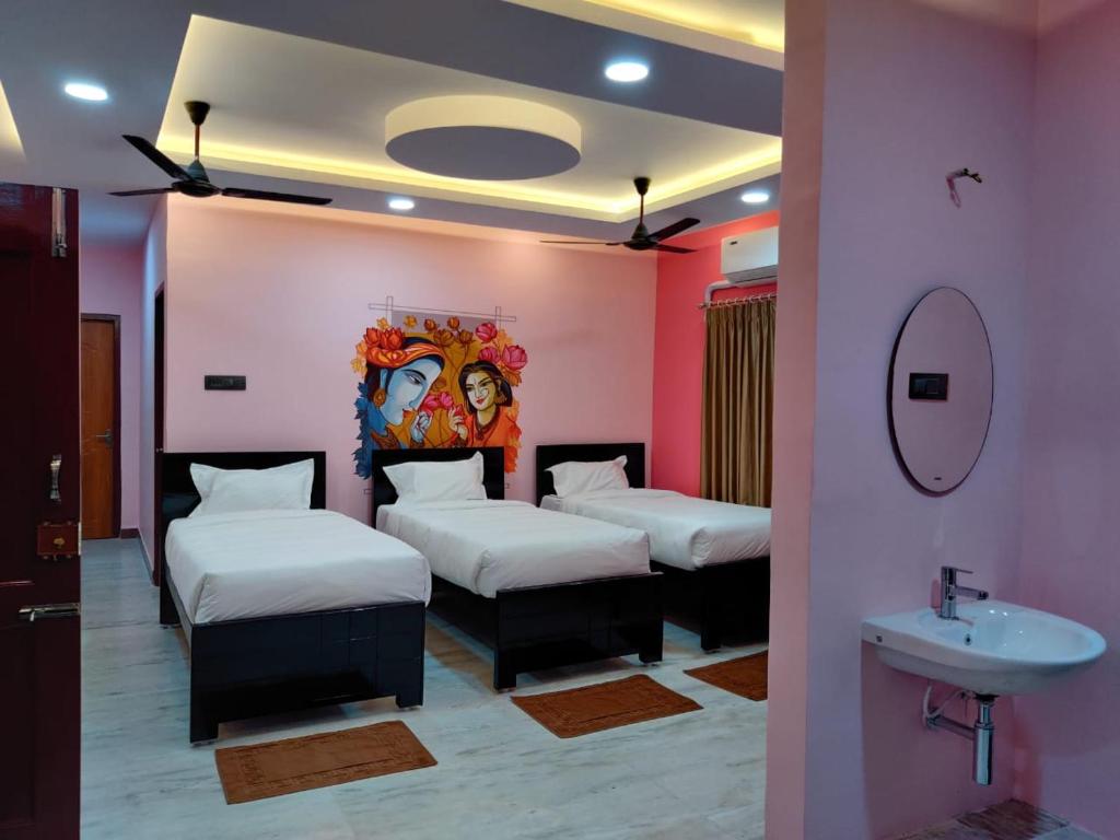 um quarto com três camas e um lavatório em Temple stay - Uma Residency and Guest House em Mayiladuthurai