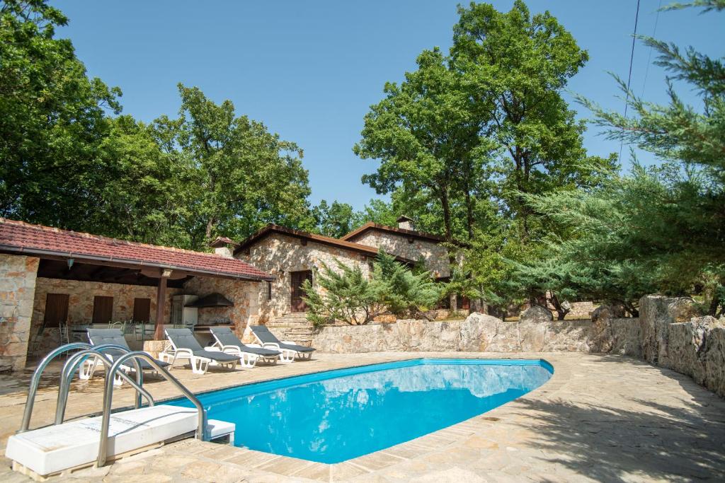 una piscina con sedie e una casa di Villa Amalia a Široki Brijeg