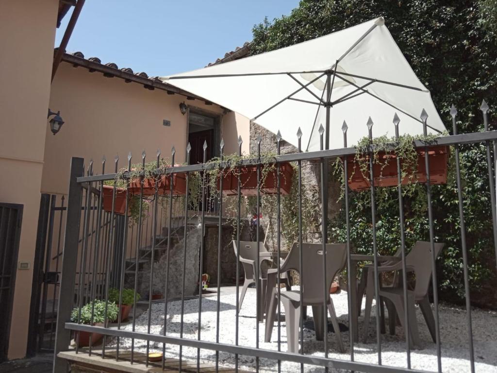une terrasse avec un parasol blanc et des chaises dans l'établissement Il Giardino di Ambra Casa Vacanze indipendente, à Viterbe