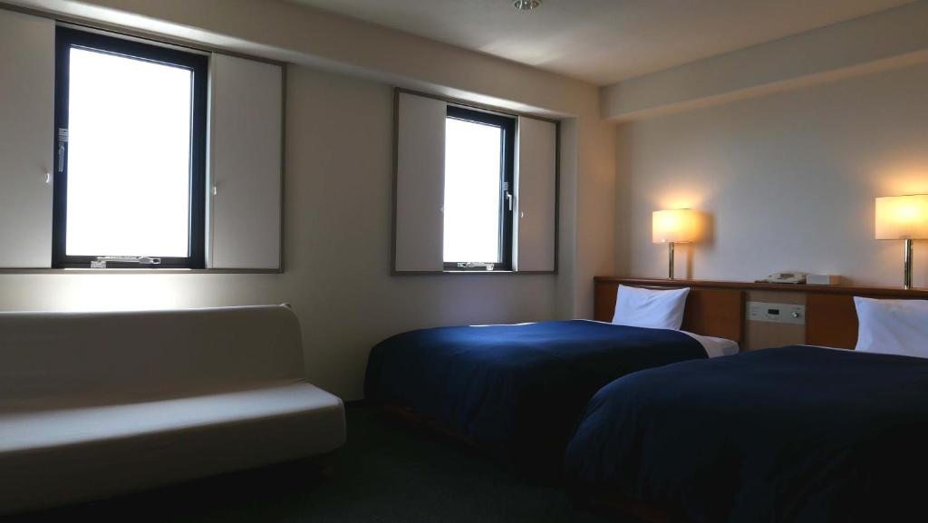 Postel nebo postele na pokoji v ubytování Tourist Hotel Hitachi
