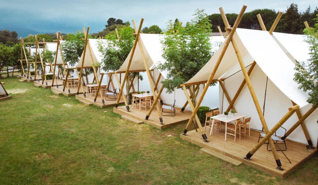 eine Reihe von Zelten mit Tischen und Stühlen in der Unterkunft Kampaoh Somo Playa in Somo