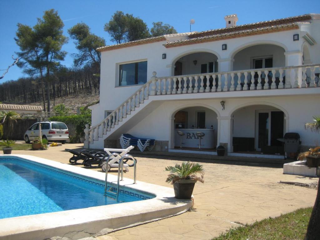 a villa with a swimming pool in front of a house at Arp in Jávea