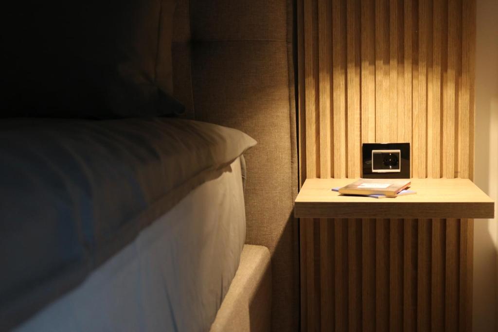 a bedroom with a bed and a clock on a night stand at W Apartman in Vrnjačka Banja