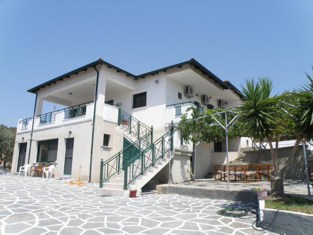 a white building with stairs and a palm tree at Villa Rodia in Potos