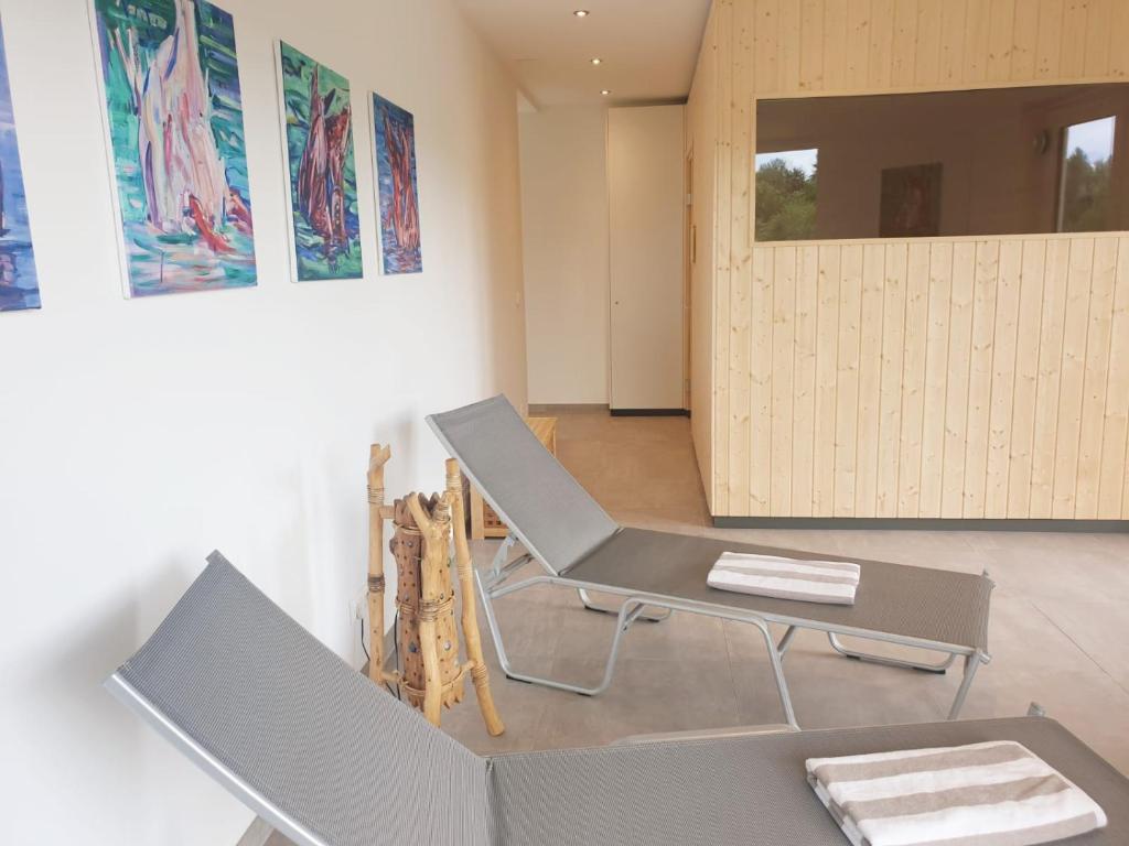 a room with a chair and a table and a door at Hotel Garni Wurzer in Velden am Wörthersee