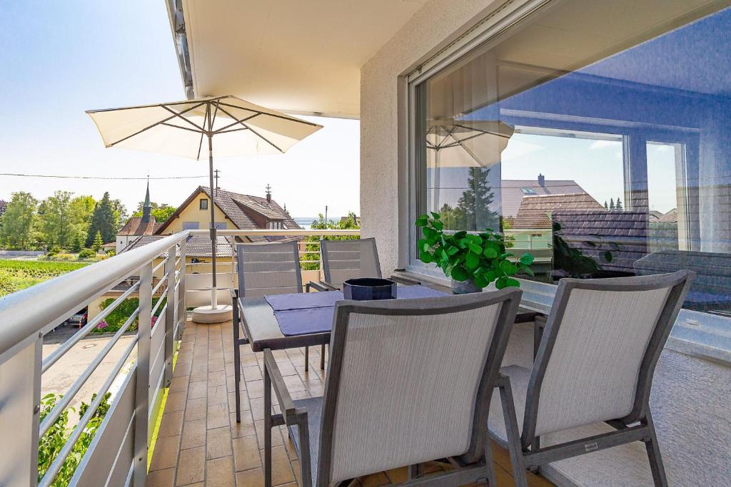 un patio avec une table et des chaises sur un balcon dans l'établissement Silvaner-Laube Ferienwohnung Silvanerlaube A, à Meersburg