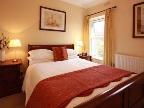 een slaapkamer met een groot bed en een raam bij Murray House in Harrogate