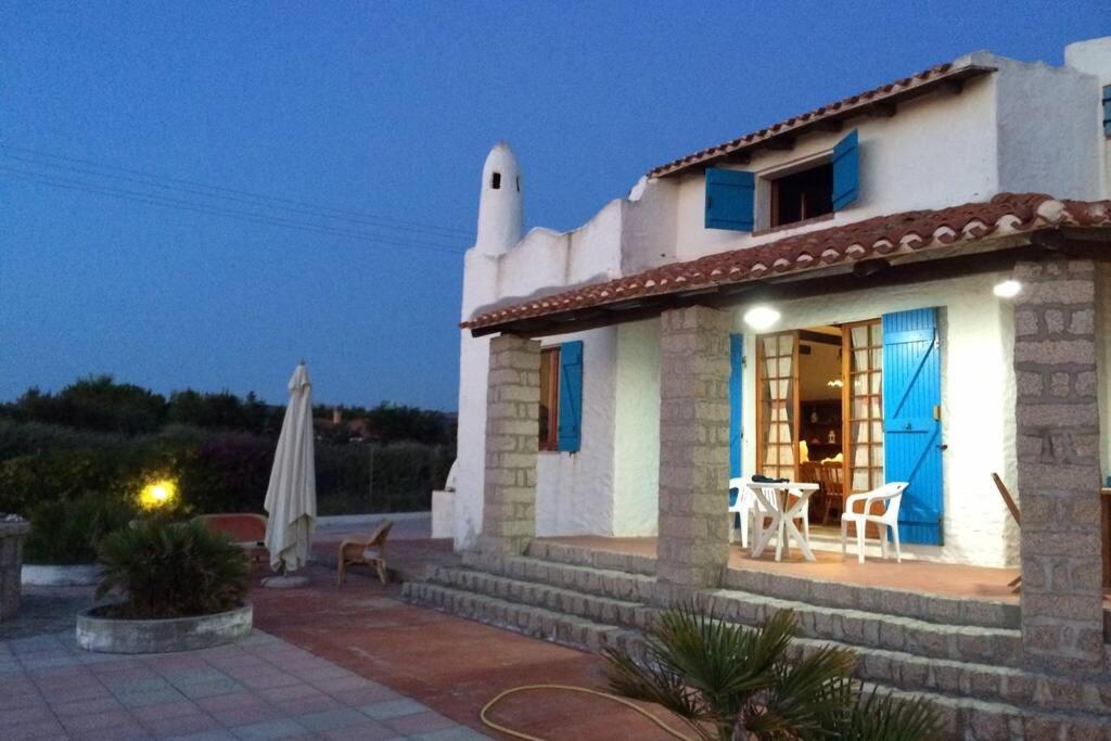een klein wit huis met een patio en een tafel bij Villa panoramica nel golfo Asinara in Sorso