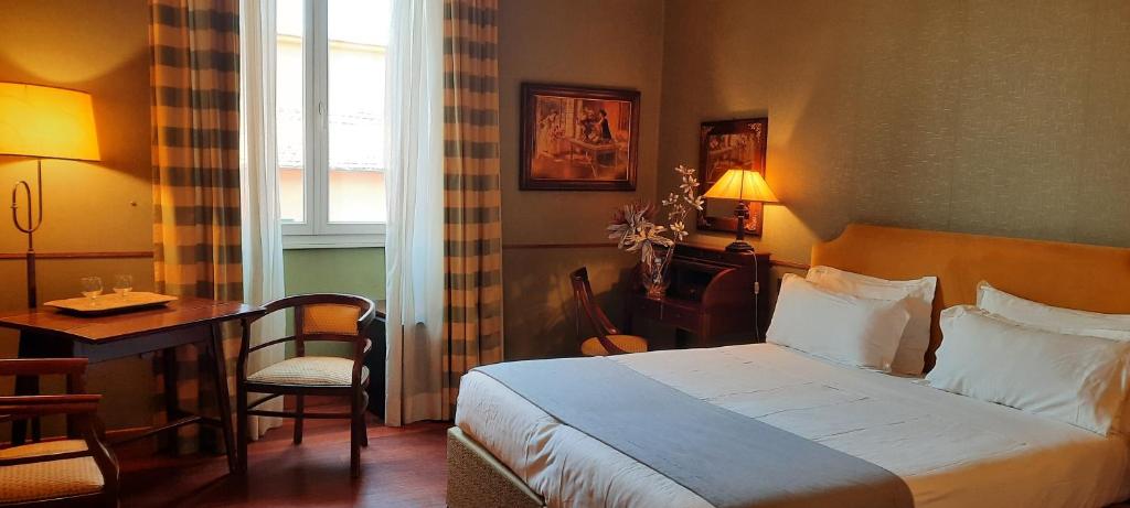a hotel room with a bed and a table and a desk at Domus Livia in Rome