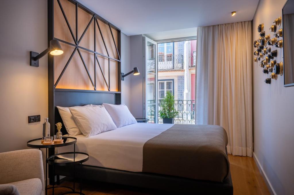 - une chambre avec un grand lit et une fenêtre dans l'établissement Ferraria XVI FLH Hotels Lisboa, à Lisbonne