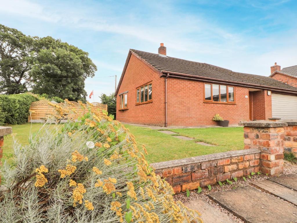 a brick house with a garden in front of it at Sandmartins in Chester