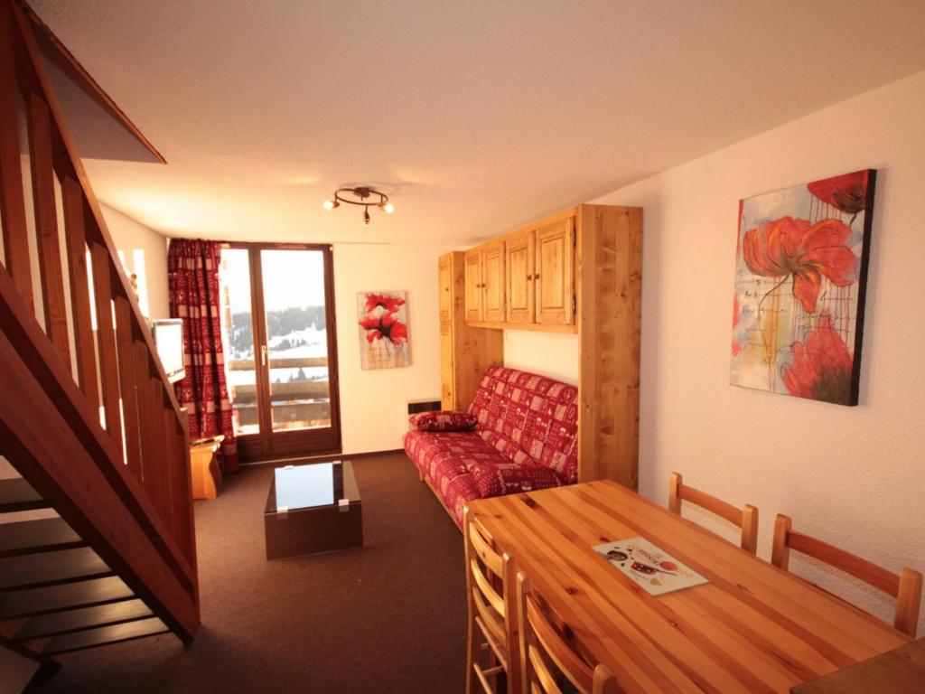 a living room with a red couch and a table at Appartement Les Saisies, 3 pièces, 6 personnes - FR-1-293-80 in Les Saisies