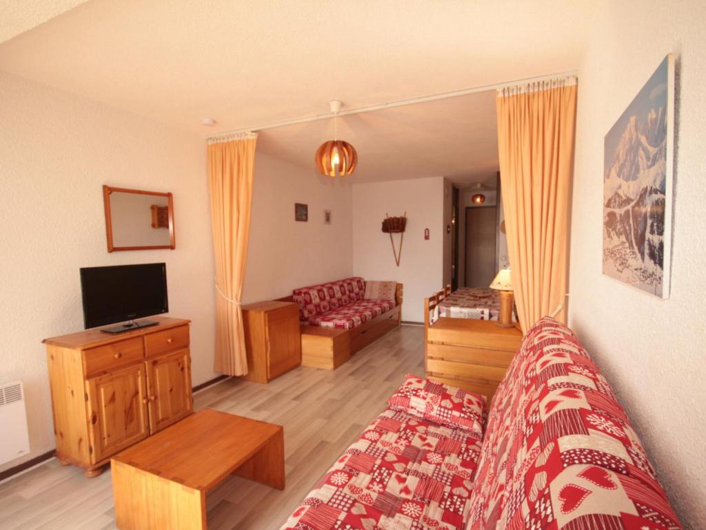 ein Schlafzimmer mit einem Bett, einem TV und einem Sofa in der Unterkunft Studio Les Saisies, 1 pièce, 4 personnes - FR-1-293-173 in Les Saisies