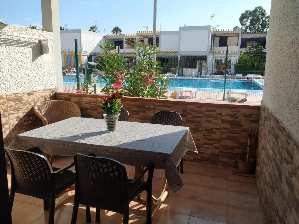 einen Tisch und Stühle auf einer Terrasse mit Pool in der Unterkunft Helios Studio Drago in Costa Del Silencio