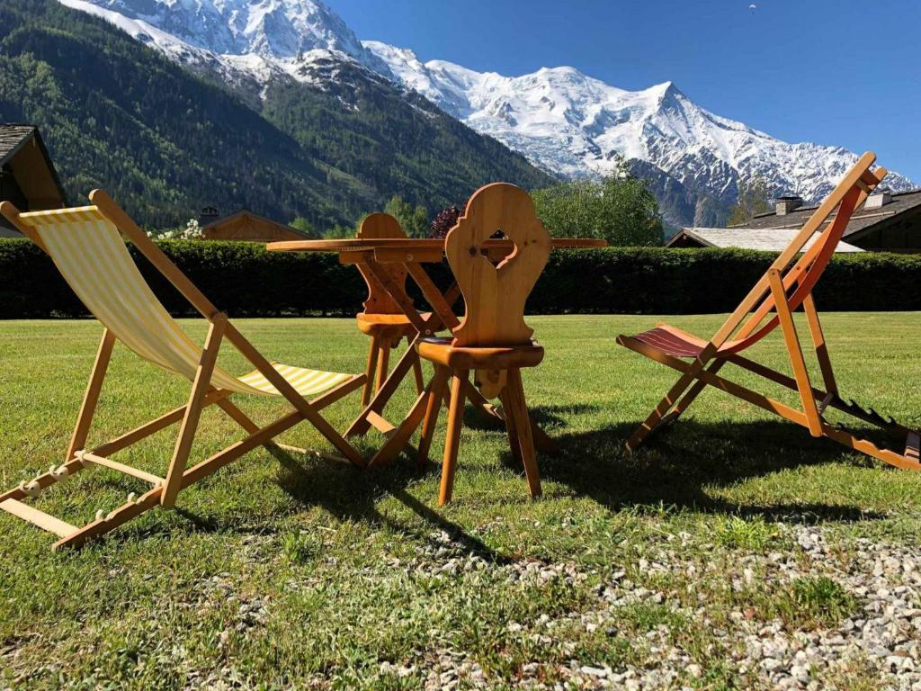 Deux chaises et une table avec des montagnes en arrière-plan dans l'établissement Appartement Chamonix-Mont-Blanc, 3 pièces, 4 personnes - FR-1-517-38, à Chamonix-Mont-Blanc
