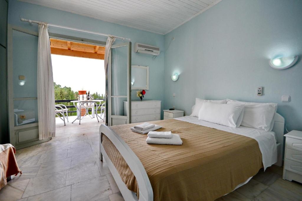 a bedroom with a large bed and a balcony at Studio Tasos in Gaios