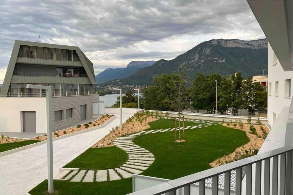 un bâtiment avec un jardin en face d'un bâtiment dans l'établissement Le Bohème Beau T2 vue lac & montagnes + garage, à Annecy