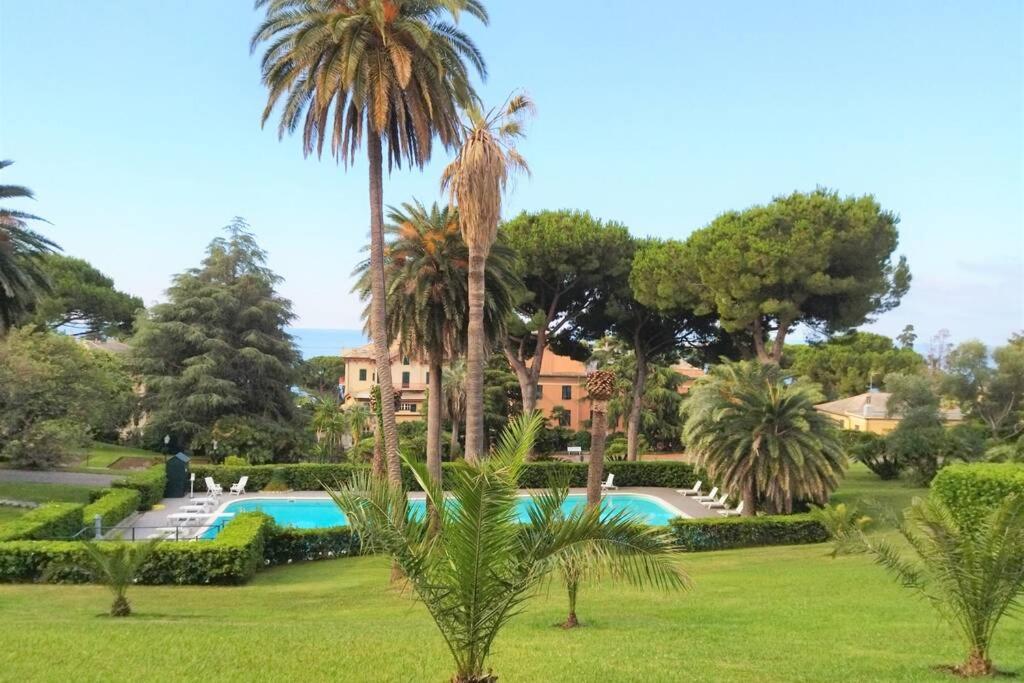 un complejo con piscina y palmeras en CasaViva - Beautiful Bilo with shared pool in Genova Nervi en Génova