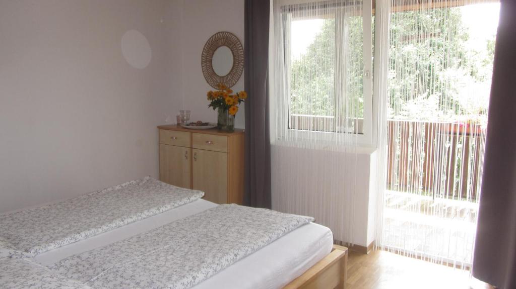 Schlafzimmer mit einem Bett, einem Spiegel und einem Fenster in der Unterkunft Appartement am See in Podersdorf am See