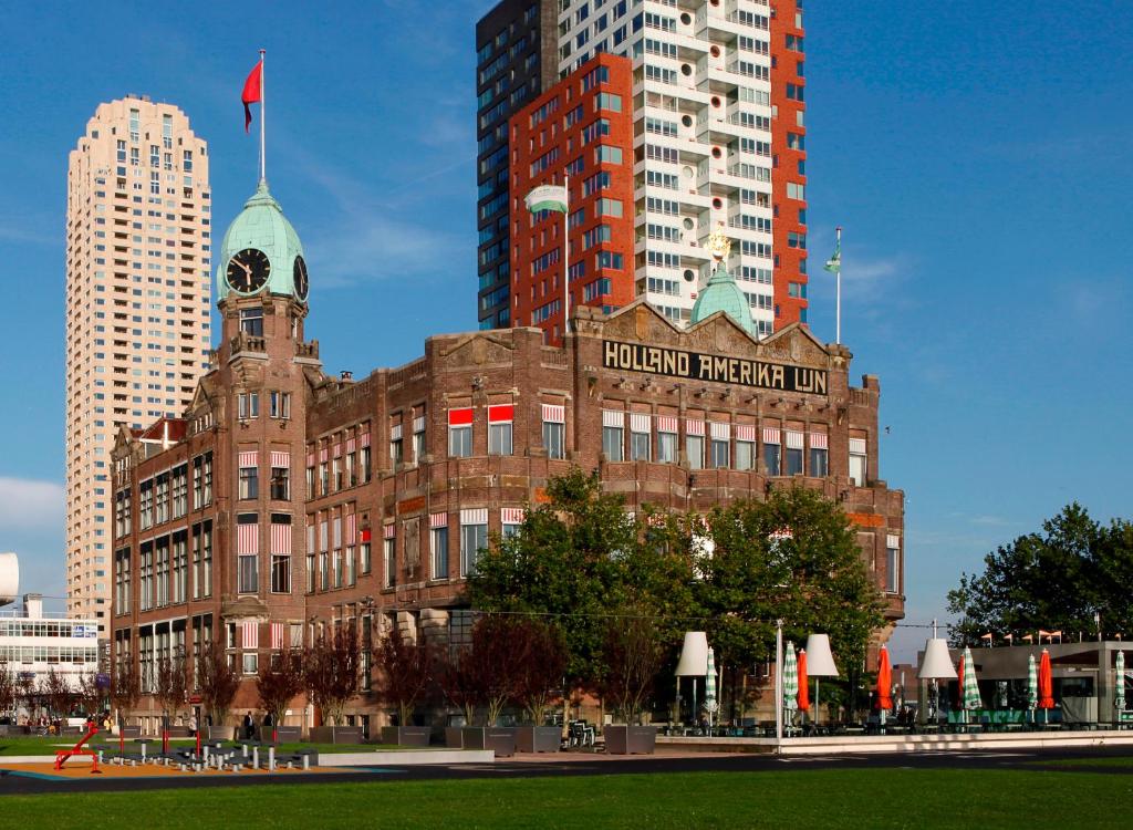 een groot bakstenen gebouw met een klokkentoren in een stad bij Hotel New York in Rotterdam