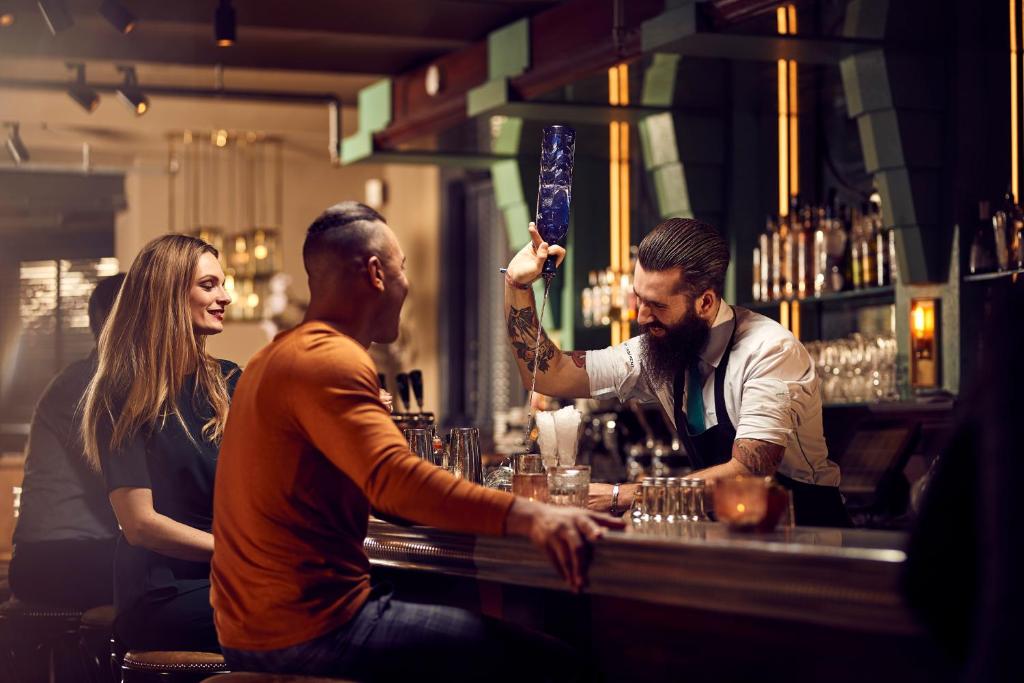 a group of people sitting at a bar at Hotel New York by WestCord in Rotterdam