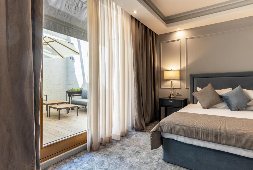 een hotelkamer met een bed en een balkon bij Dvoryansky Hotel in Odessa