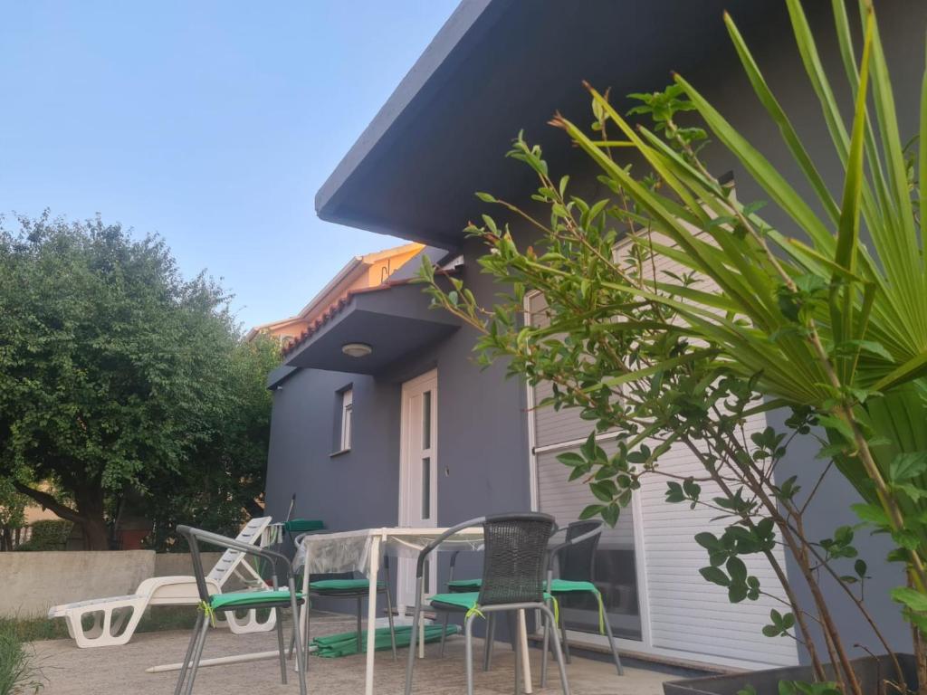 a patio with chairs and tables in front of a house at Apartman Julka in Sukošan