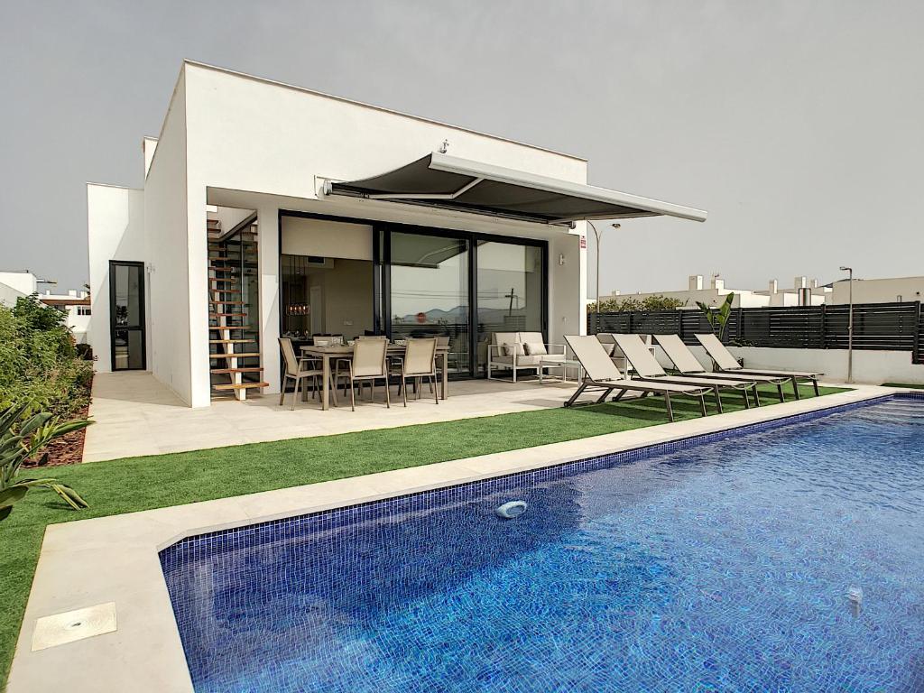 a house with a swimming pool in front of a house at Villas Alamos - 4509 in Mar de Cristal