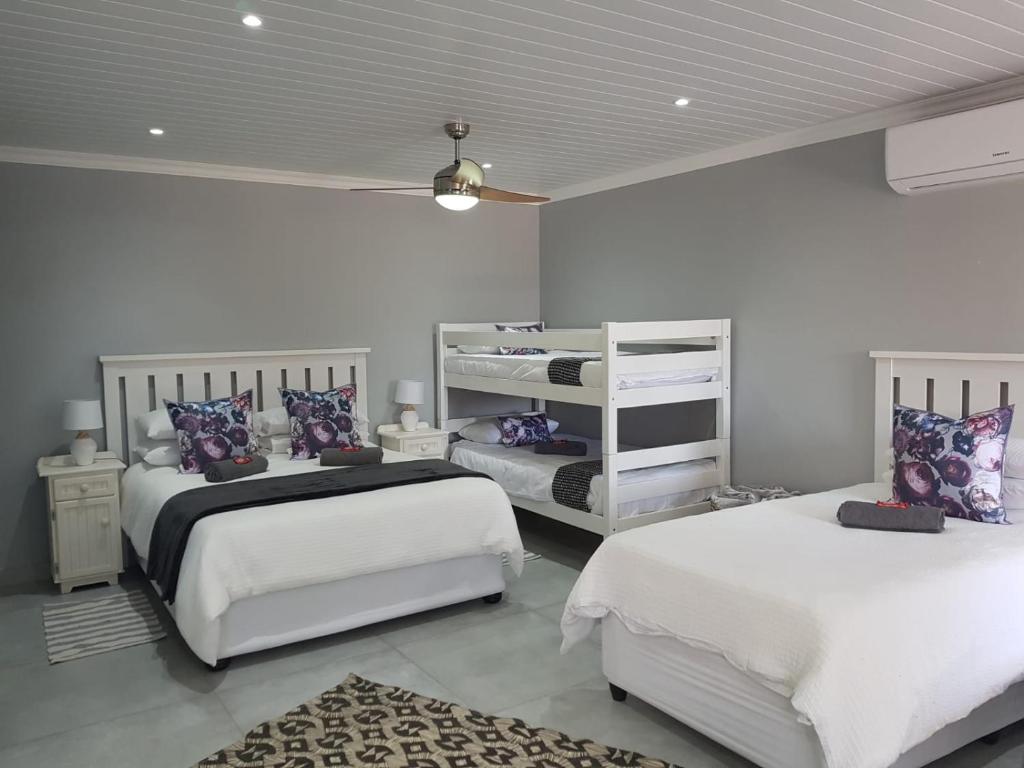 a bedroom with two beds and two bunk beds at Akkerhuis Deluxe Family Room in Bloemfontein