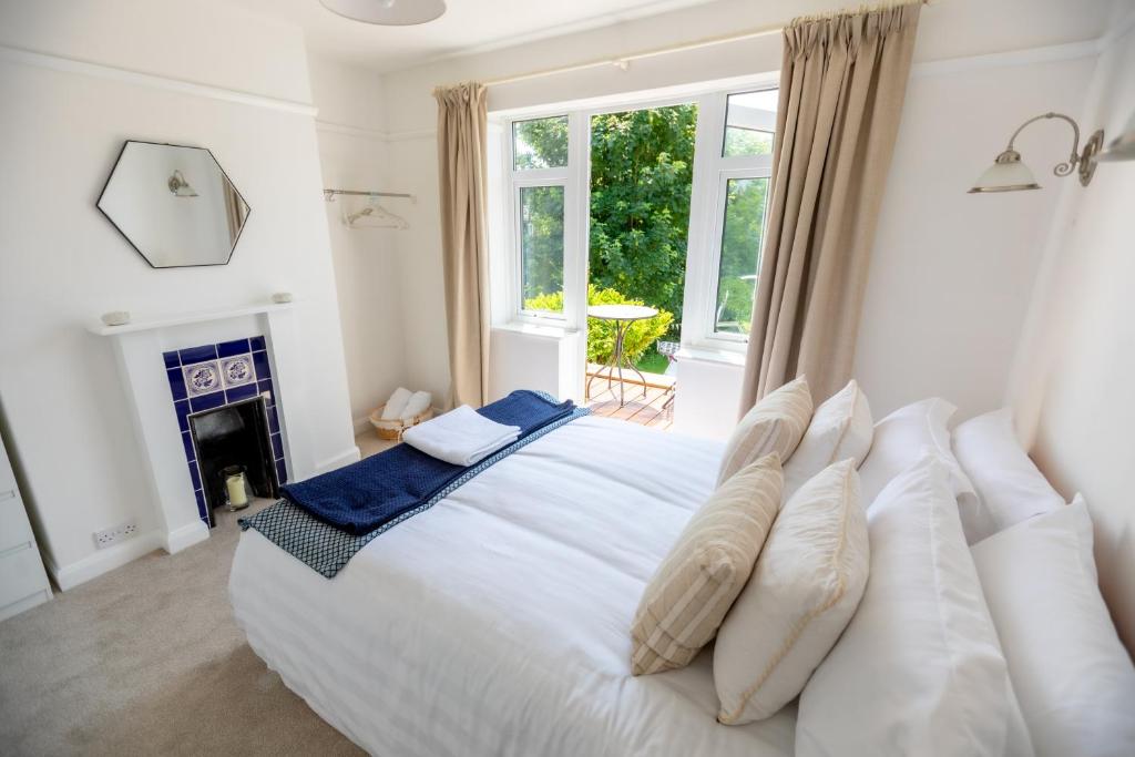 a bedroom with a large white bed and a fireplace at 'Sandy Bottom' Broadstairs by the beach in Broadstairs