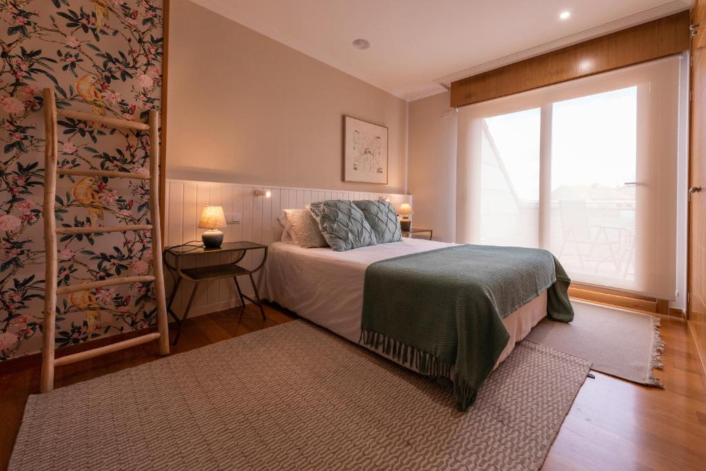 a bedroom with a bed and a window at Ático en Isla de la Toja in Isla de la Toja