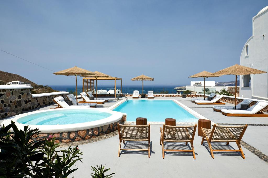- une piscine dans un complexe avec des chaises et une table dans l'établissement Symmetry Suites, à Akrotiri