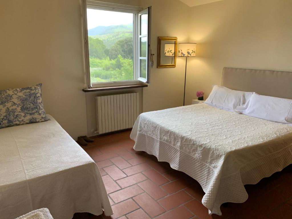 a bedroom with two beds and a window at B&B I Ligustri in Lucca