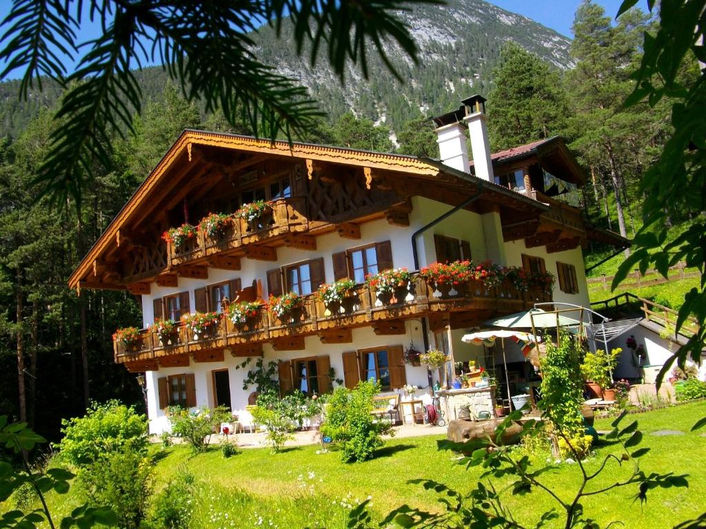 ein Haus mit Blumenkästen auf der Vorderseite in der Unterkunft Gästehaus Arnspitzblick in Scharnitz