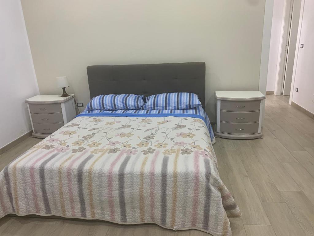 um quarto com uma cama e duas mesas de cabeceira em La Rosa del Vesuvio em Boscotrecase