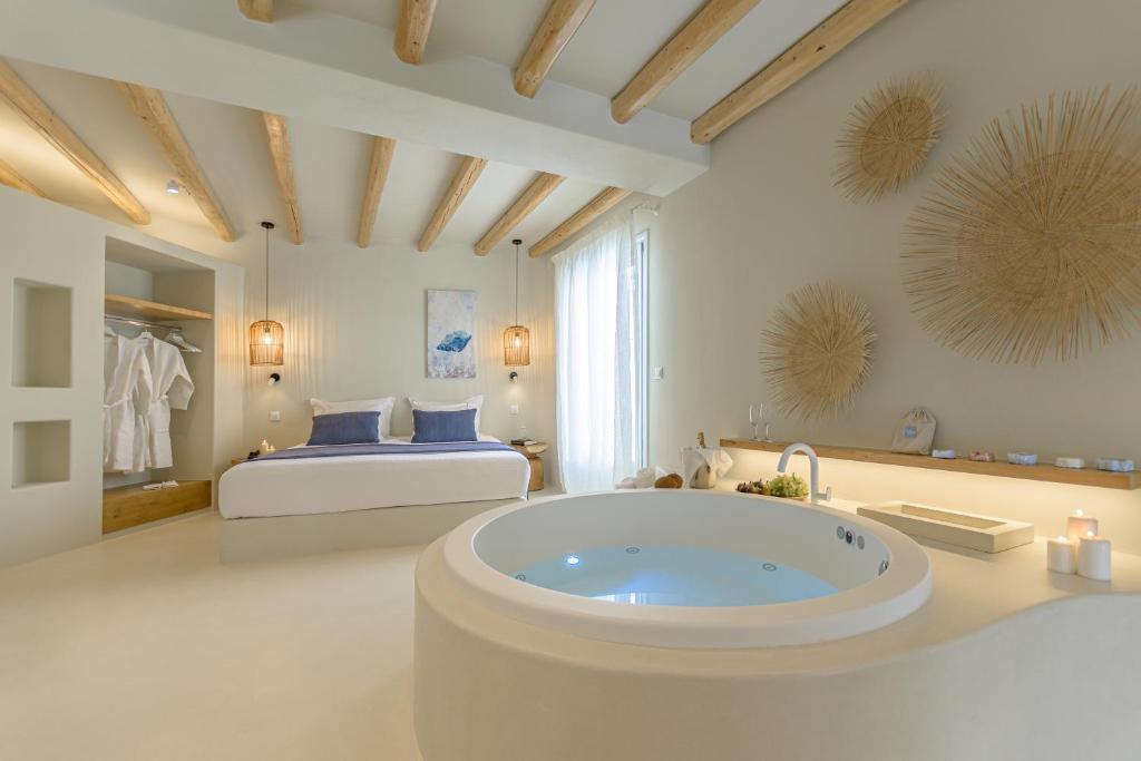 a large bathroom with a tub in a bedroom at Antony Suites (Adults Only) in Naxos Chora